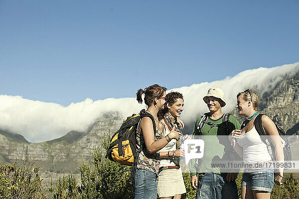 Male and female tourist discussing while standing against sky during sunny day