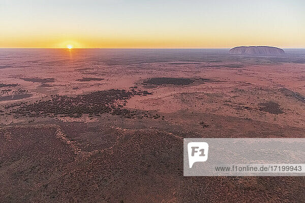 Australia  Northern Territory  Aerial view of desert landscape of Uluru-Kata Tjuta National Park at sunrise with Uluru in background