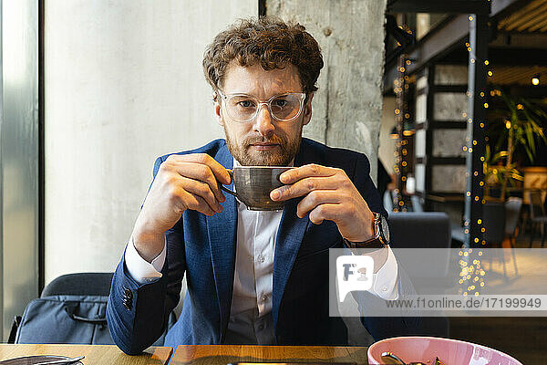 Businessman wearing suit while having coffee at cafe