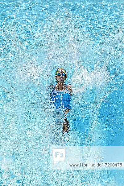 Frau schwimmt im klaren blauen Schwimmbad
