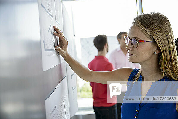 Female architect looking at whiteboard in office
