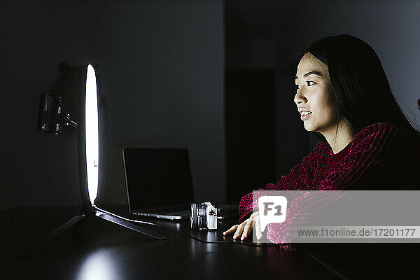 Chinesische Vloggerin  die vor einem beleuchteten Ringlicht sitzt  während sie sendet