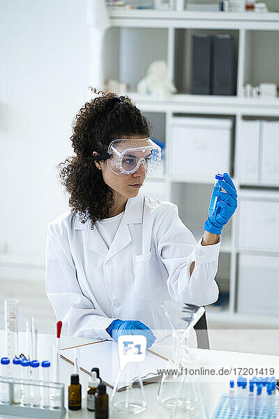 Wissenschaftlerin bei der Analyse einer chemischen Lösung im Reagenzglas im Labor