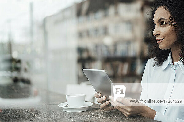 Young businesswoman using digital tablet while sitting at cafe