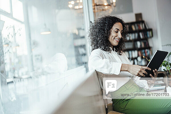Junge Geschäftsfrau  die ein digitales Tablet benutzt  während sie in einem Café sitzt