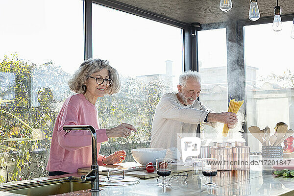 Älteres Paar beim gemeinsamen Kochen in der Küche zu Hause