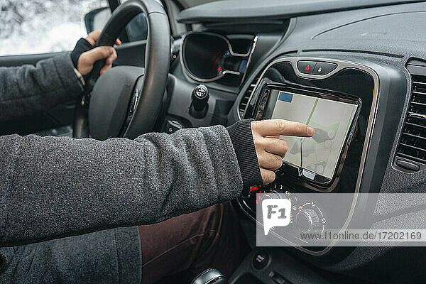 Mann benutzt Navigationskarte im Auto sitzend