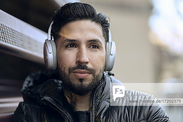 Handsome man with wireless headphones looking away