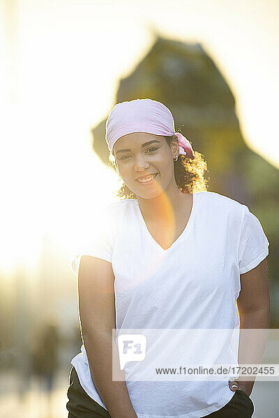 Lächelnde Frau mit Kopftuch bei Sonnenuntergang