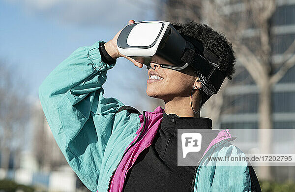 Glückliche Frau mit Virtual-Reality-Headset in der Stadt