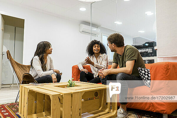 Multiethnische Unternehmerinnen und Unternehmer diskutieren in der Lobby eines Büros