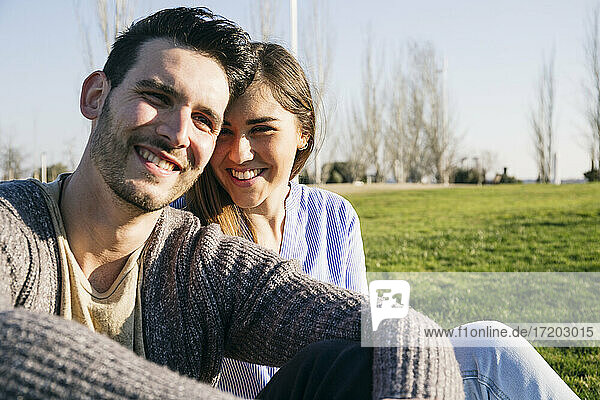 Smiling couple sitting together in park