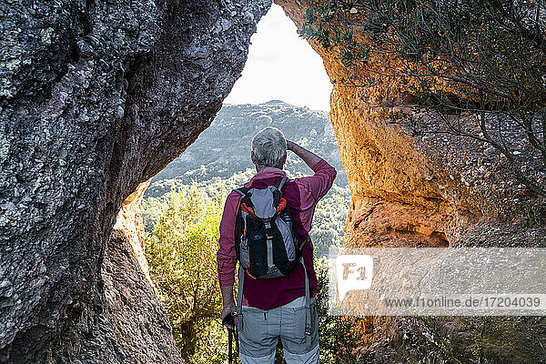 Backpacker admiring view while standing in natural park of Sant Llorenc del Munt i l'Obac at Catalonia  Spain