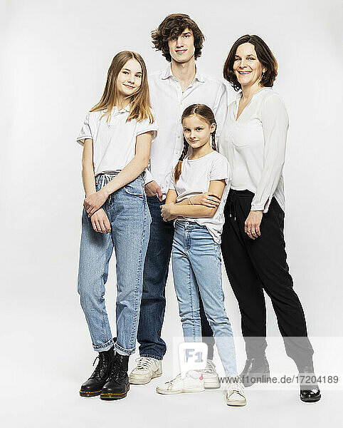 Mutter und Kinder stehen zusammen vor einem weißen Hintergrund