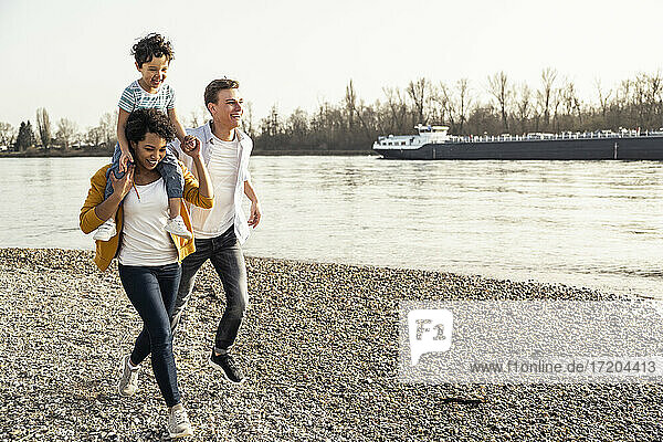 Glückliche Familie beim Laufen auf dem Kieselstein in den Ferien