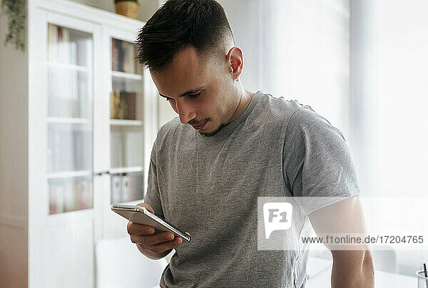 Male entrepreneur using smart phone at home office