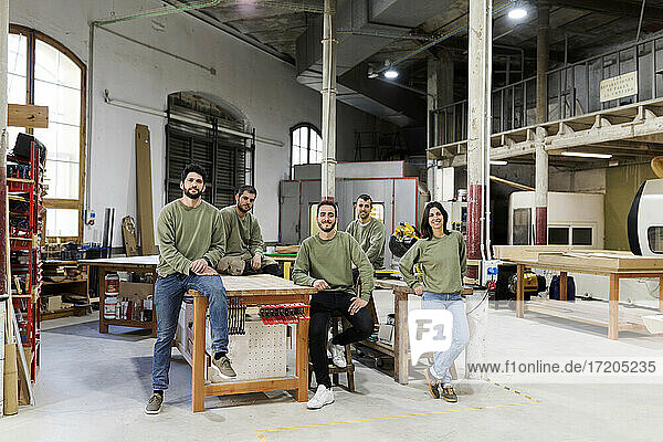 Male and female colleagues at furniture workshop
