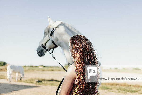 Junge Frau steht bei einem Pferd im Reitsportzentrum