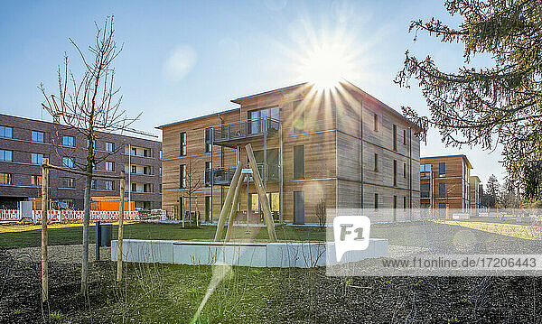 Deutschland  Bayern  München  Sonne scheint über Neubaugebiet mit energieeffizienten Holzhäusern