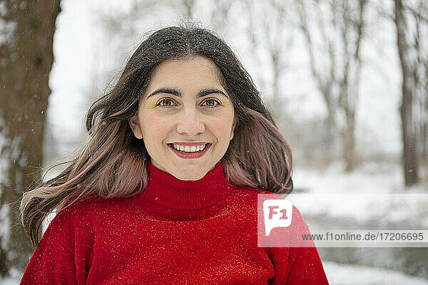 Lächelnde schöne Frau mit Lidschatten im Winter