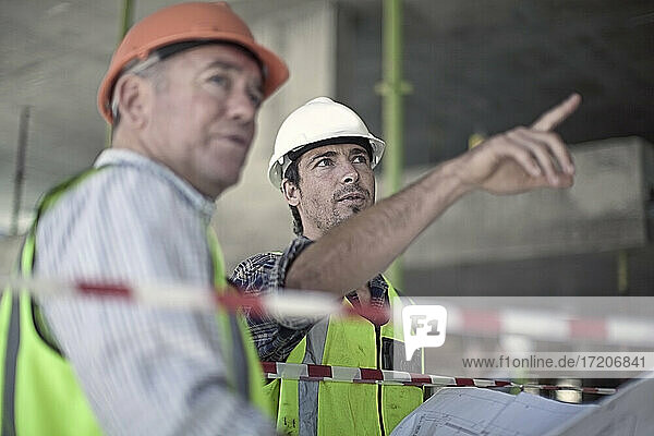 Two male construction workers talking at construction site