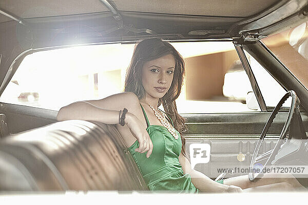 Young woman staring while sitting in vintage car