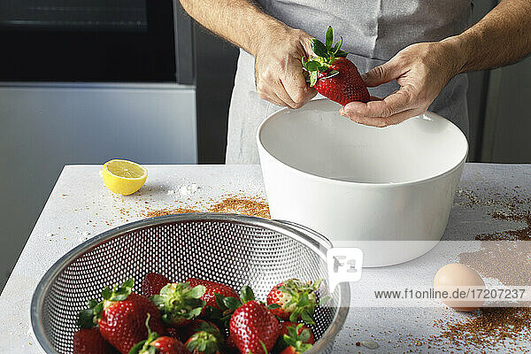 Hands of man preparing fresh strawberries
