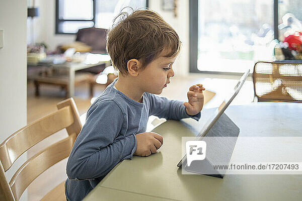 Boy learning through digital tablet at home