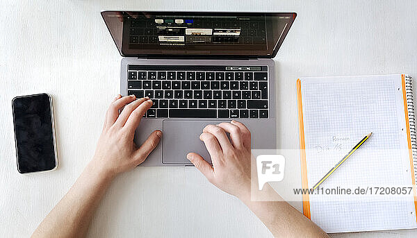 Mann mit Laptop auf dem Schreibtisch im Heimbüro
