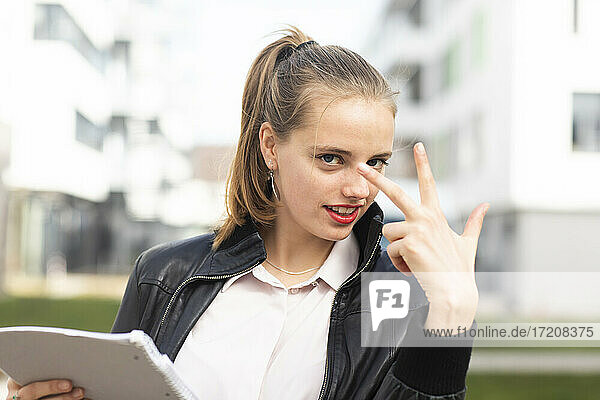 Porträt einer jungen blonden Frau mit drei Fingern