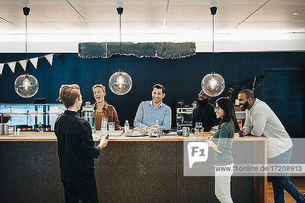 Business people discussing over table at cafeteria in office