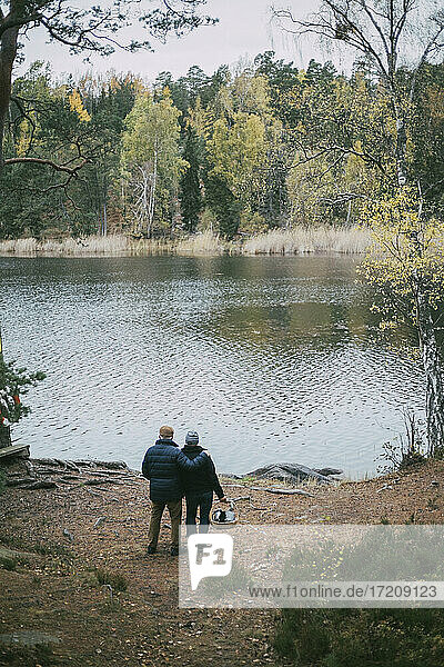 Homosexuelles Paar schaut auf den Fluss  während es im Wald steht