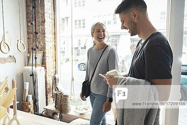Weibliche und männliche Kunden lachen  während sie im Designstudio stehen