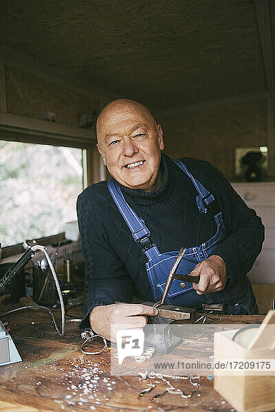 Porträt eines lächelnden männlichen Schweißers in der Werkstatt