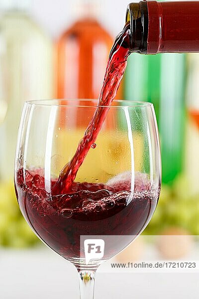 Wein einschenken eingießen aus Weinflasche Weinglas Rotwein Flasche hochkant - Stockfoto