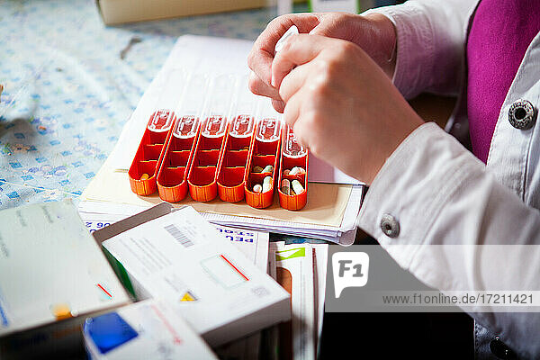 Krankenschwester bereitet die Pillendose für ihren Patienten vor.