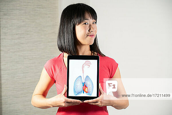 Frau hält Bildschirm mit Zeichnung von Herz und Lunge