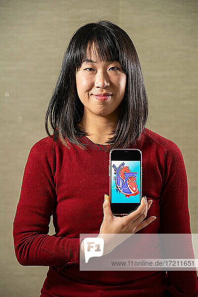 Woman holding a screen with a heart cutout design