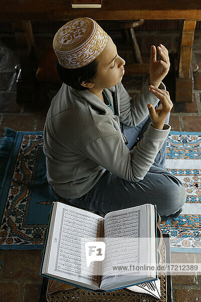 Muslimischer Junge betet zu Hause in Frankreich