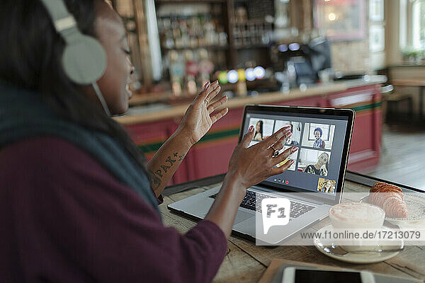 Frau Videokonferenz mit Kollegen am Laptop auf Cafe Tisch