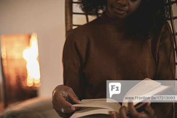 Junge Frau liest Buch zu Hause