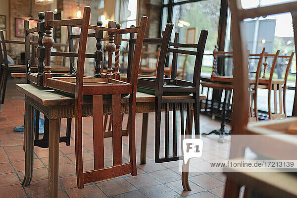 Holzstühle umgedreht auf Tischen in leerem Restaurant