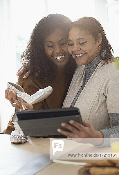 Glückliche Mutter und Tochter mit Hochzeit Schuhe und digitale Tablette