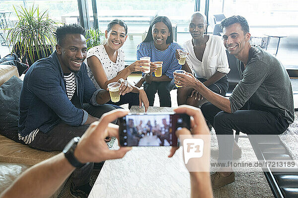 POV Mann mit Smartphone fotografiert Freunde beim Biertrinken