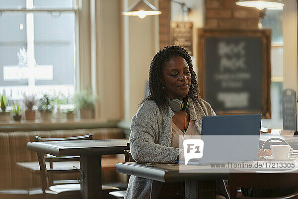 Geschäftsfrau arbeitet am Laptop im Café