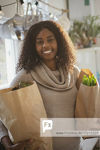 Portrait happy young woman with grocery bags