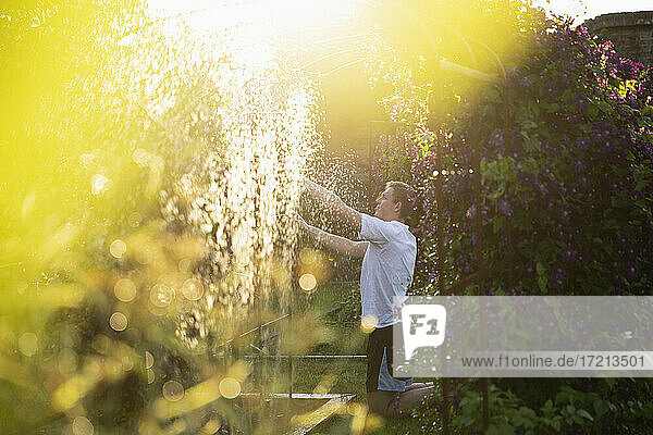 Mann Einstellung Sprinkler in sonnigen Sommergarten