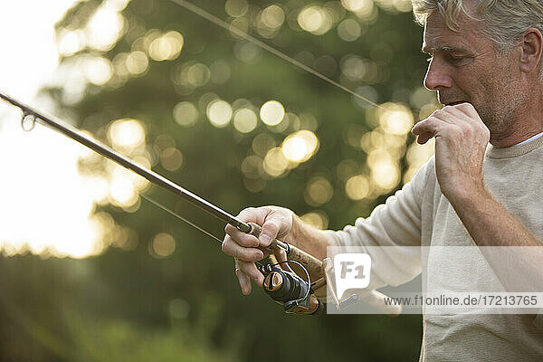 Mann bereitet Fliegenfischerschnur vor