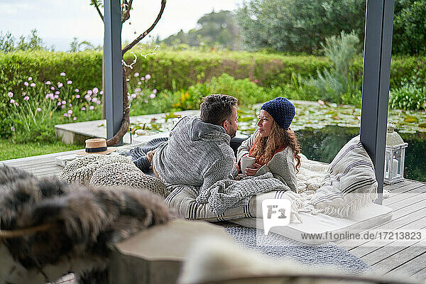 Romantisches Paar entspannt sich auf luxuriösen Hotel-Terrassen-Kissen