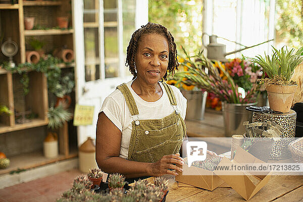 Porträt weiblichen Florist Boxen winzigen sukkulenten Pflanzen im Garten-Shop